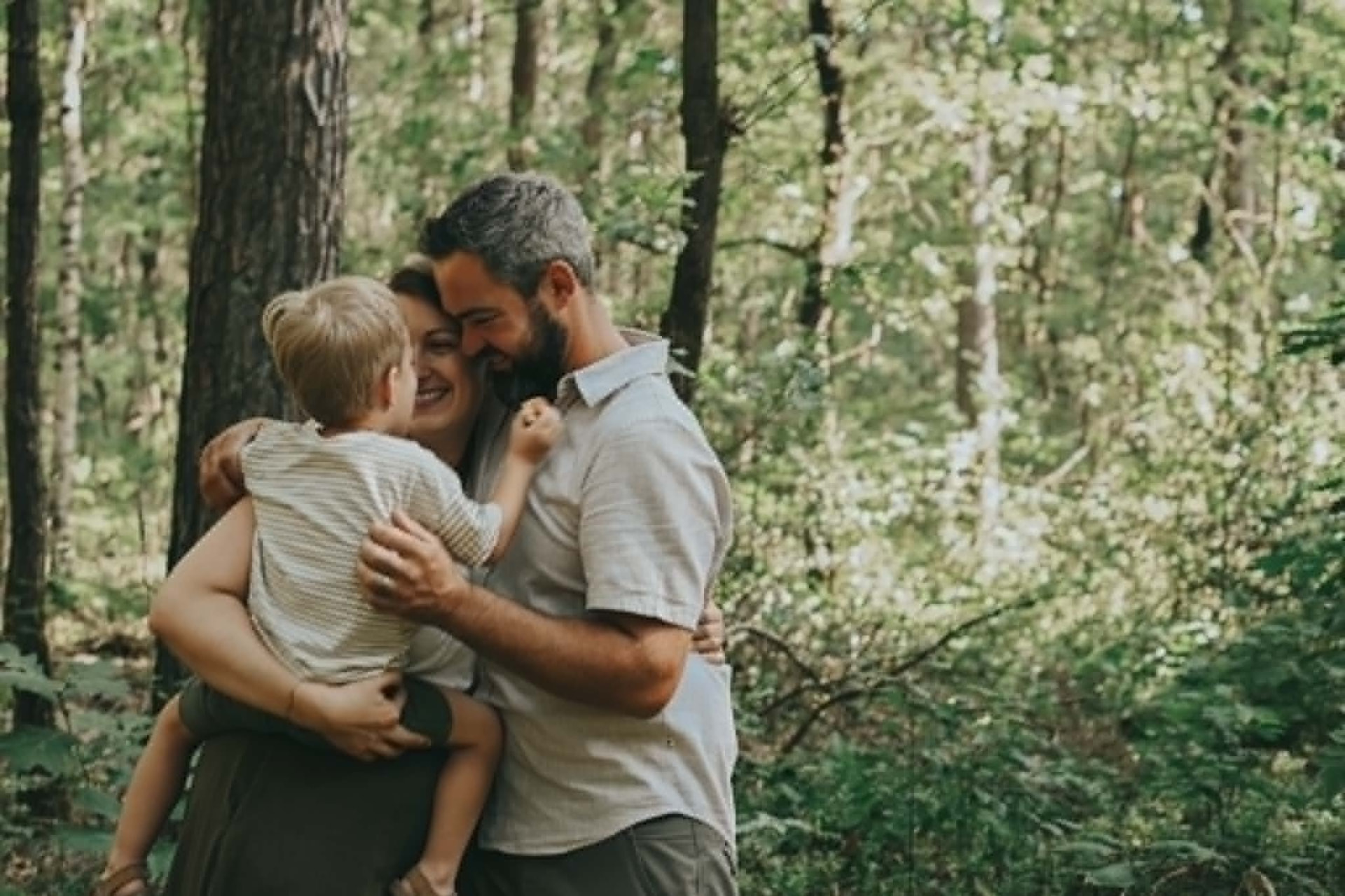 Gezin met kindje knuffelend in het bos