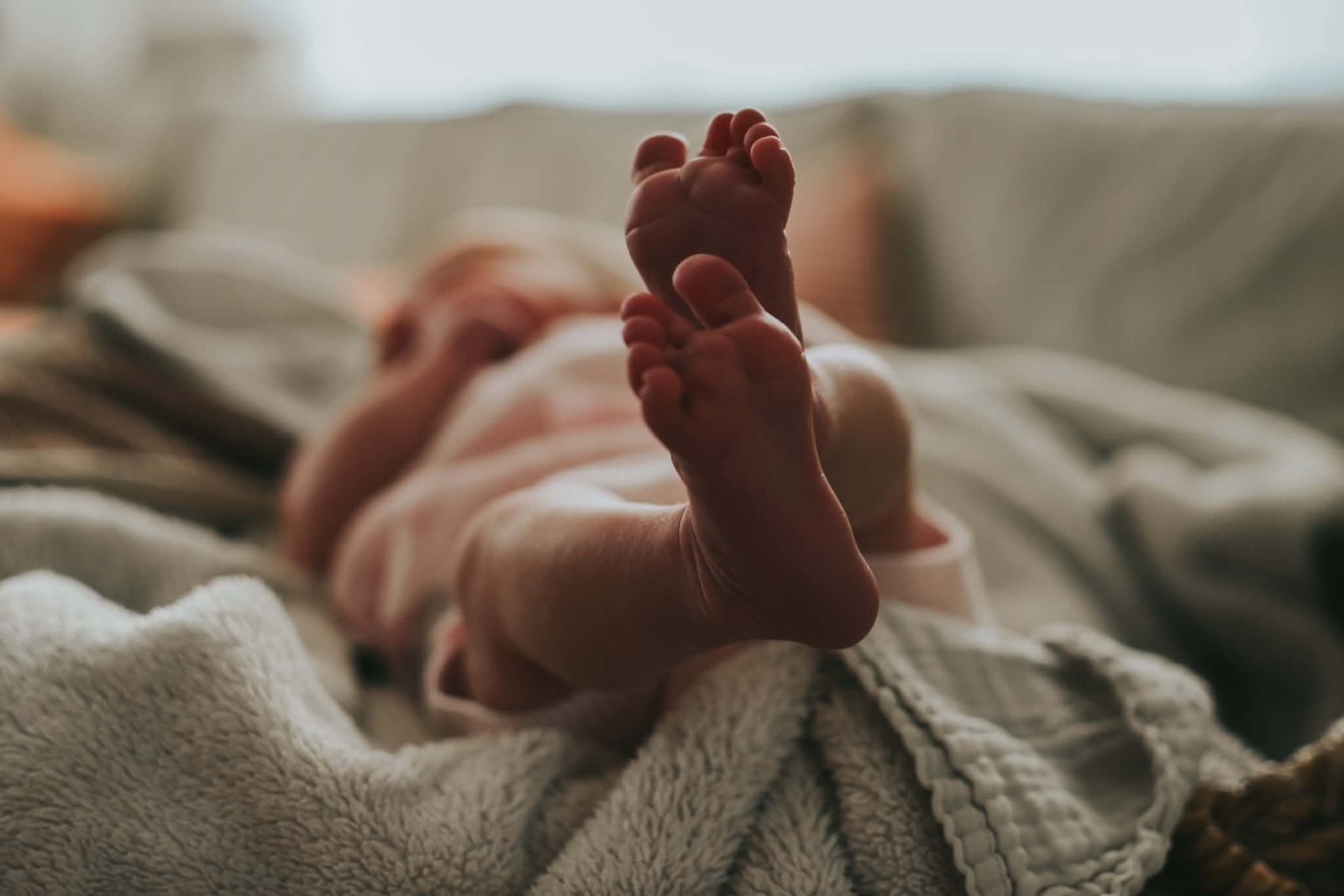 Kleine babyvoetjes op een zachte deken